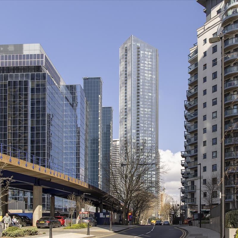 The dramatic, soaring height of Amory Tower in Canary Wharf, capturing its sleek metallic finish and panoramic windows.